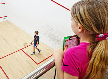 Young female player refereeing a squash match